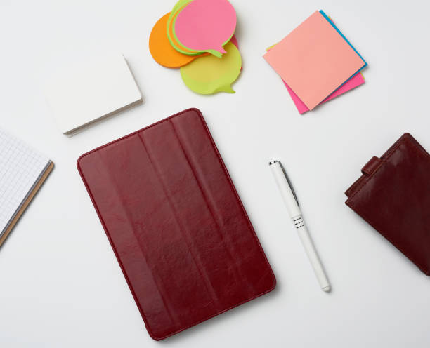 istock open paper notebooks and pen, brown wallet on a white table 1217812943