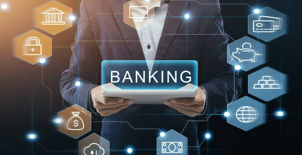 istock Online banking. Businessman holding tablet computer on dark background, collage with financial pictograms. Panorama 1217813023