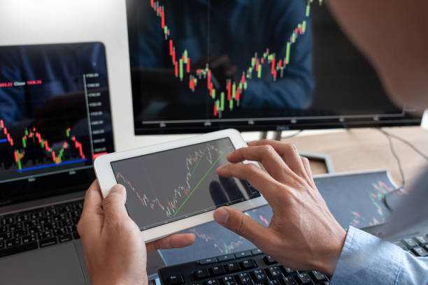 istock Working business man, team of broker or traders talking about forex on multiple computer screens of stock market invest trading financial graph charts data analysis 1217814923