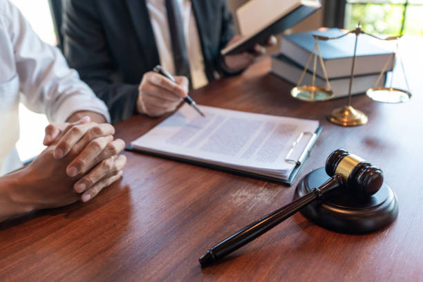 istock Lawyer working with client discussing contract papers with brass scale about legal legislation in courtroom, consulting to help their customer. 1217815185