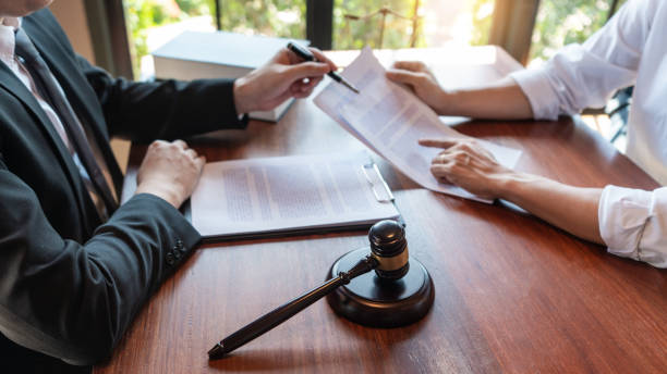 istock Lawyer working with client discussing contract papers with brass scale about legal legislation in courtroom, consulting to help their customer. 1217815253