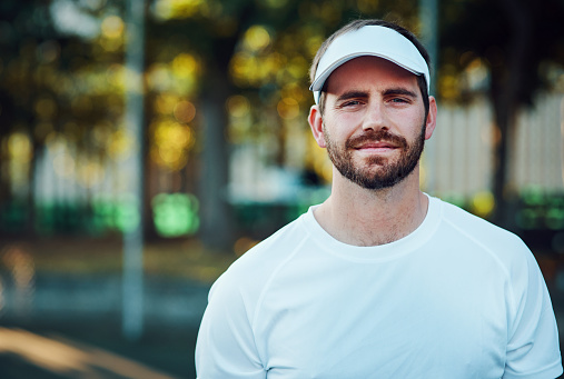 Portrait of a sporty young man standing on a tennis court