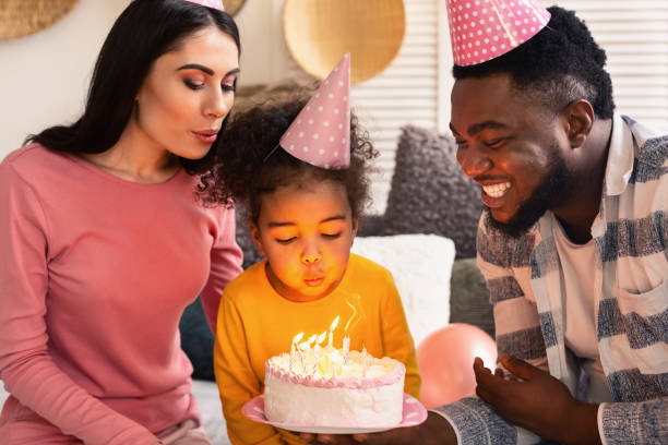 istock Family blowing out candles on a cake 1217815826