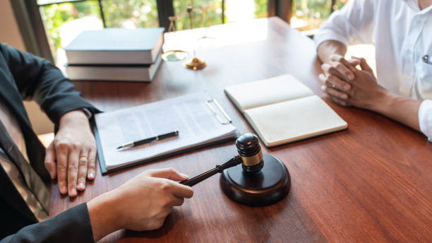 istock Lawyer working with client discussing contract papers with brass scale about legal legislation in courtroom, consulting to help their customer. 1217817394