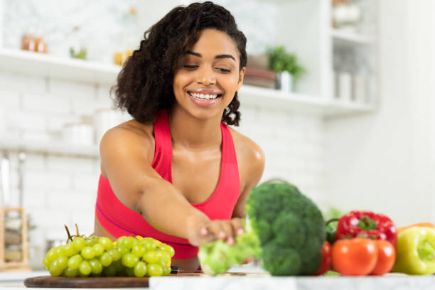 istock Happy young black woman preparing vegetable salad 1217817426