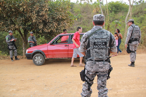 pau brasil, bahia / brazil - may 3, 2012: National Force military personnel approach vehicles and people traveling in rural Pau Brasil  after armed conflict between Pataxo Hahahae ethinics and farmers.