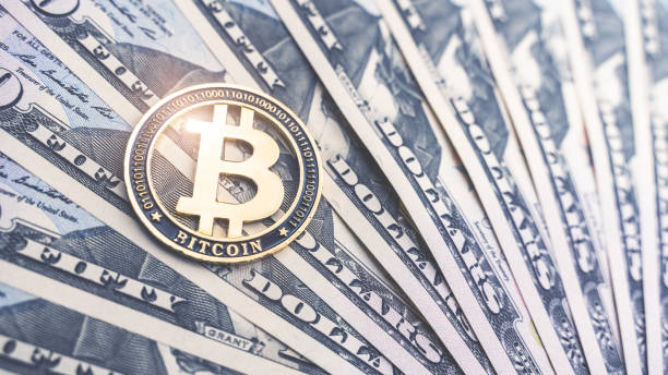 istock Physical version of Bitcoin and dollar banknotes. Exchange bitcoin for a dollar symbol. Conceptual image for worldwide cryptocurrency and digital payment system 1217817825