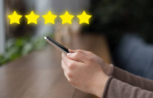 istock Girl hand holding cell phone with icon five star symbol 1217818965