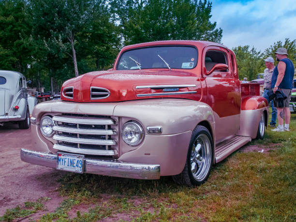 Moncton, New Brunswick, Canada - July 10, 2010 : Mild customized 1949 Mercury pickup truck at Annual Atlantic Nationals Automotive Extravaganza, Centennial Park, Moncton, New Brunswick, Canada. Two men stand behind the pickup and chat.