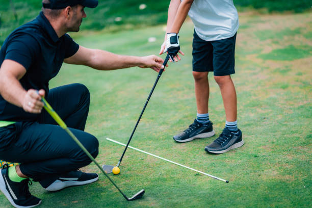 istock Golf – Personal Training. Golf Instructor Teaching Young Boy How to Play Golf. 1217820798