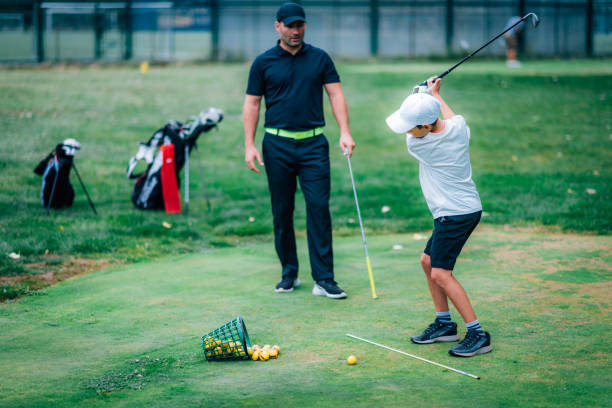 istock Golf – Personal Training. Golf Instructor Teaching Young Boy How to Play Golf. 1217821080