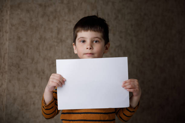 istock boy, white paper . Place for text. Mockup. 1217821138