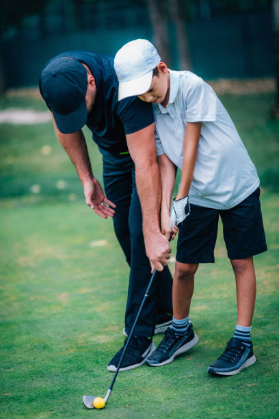 istock Golf – Personal Training. Golf Instructor Teaching Young Boy How to Play Golf. 1217822511