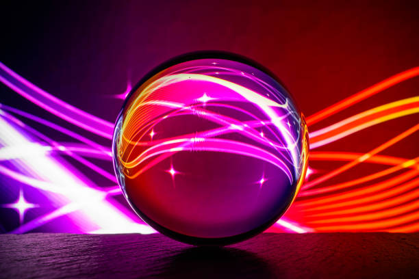 istock Crystal glass ball is lying on a stone surface on the colorful abstract background. 1217824550