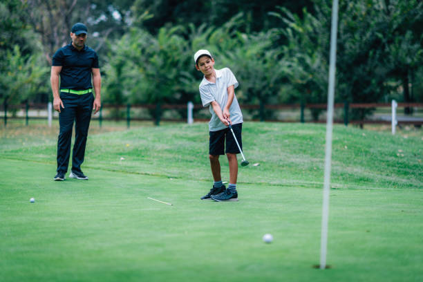 golfe colocando treinamento. instrutor de golfe com garoto praticando no verde de colocar - golf green practicing sports training - fotografias e filmes do acervo