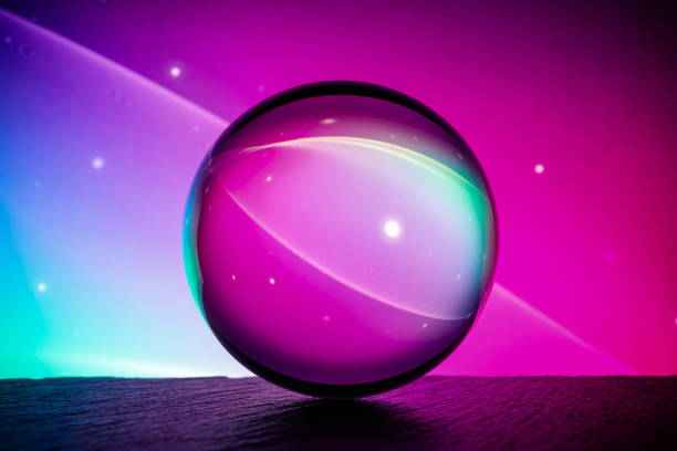 istock Crystal glass ball is lying on a stone surface on the colorful abstract background. 1217824783
