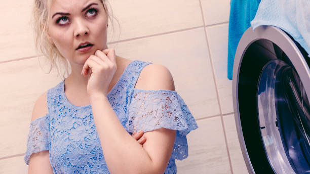 istock Sad girl with broken washing machine 1217824830