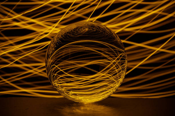 Crystal glass ball is lying on a stone surface on the colorful abstract background.