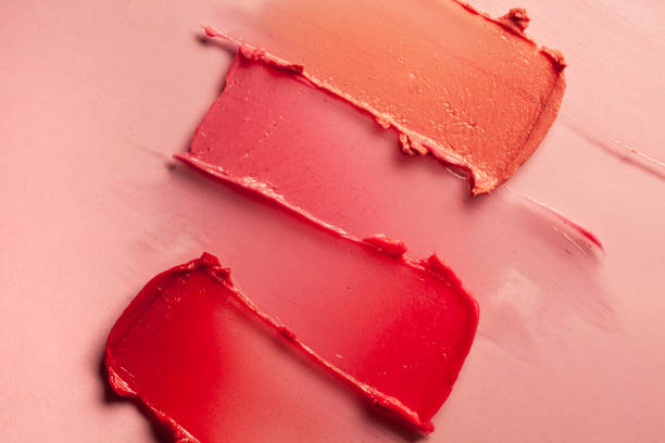 lápiz labial rosa púrpura rojo sobre fondo rosa terracota - maquillaje fotografías e imágenes de stock