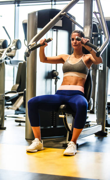 istock Fit young female athlete strength training her upper body on a chest press 1217825152