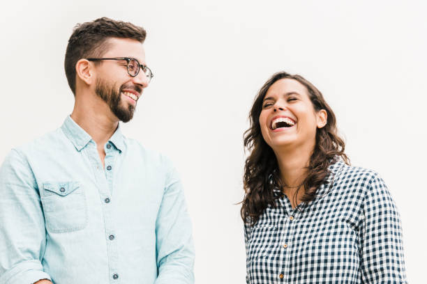 positive funny guy making his girlfriend laugh - couple indoors studio shot horizontal imagens e fotografias de stock