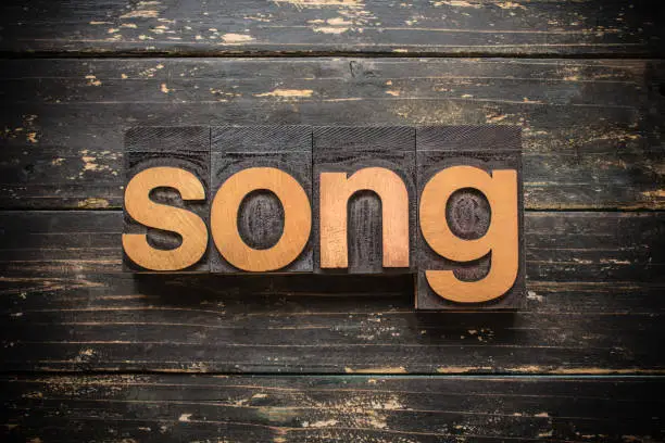 The word "SONG" written in vintage wood letterpress type on a vintage rustic background.