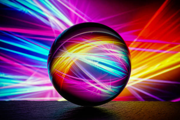 istock Crystal glass ball is lying on a stone surface on the colorful abstract background. 1217825420