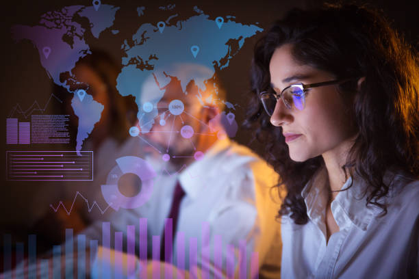 istock Tired businesspeople working late and virtual statistic graphics 1217825499