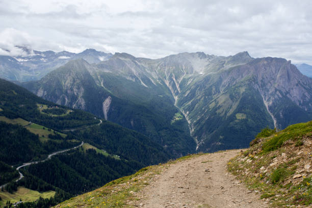 istock dirt road in Switzerland, green meadows and mountains 1217826907