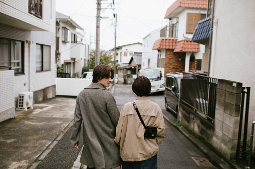 Man looking over the shoulder while walking on the street with his girlfriend.