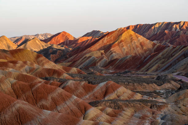 Colorful Zhangye Danxia National Geopark or China's Rainbow Mountains during sunset golden hour, Gansu, China Zhangye Danxia is known for the unusual colours of the rocks, which are smooth, sharp and several hundred meters tall. They are the result of deposits of sandstone and other minerals that occurred over 24 million years. zhangye danxia geopark china stock pictures, royalty-free photos & images
