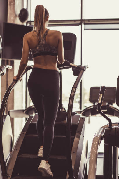istock Rear view of young woman using stair climbing machine 1217829044