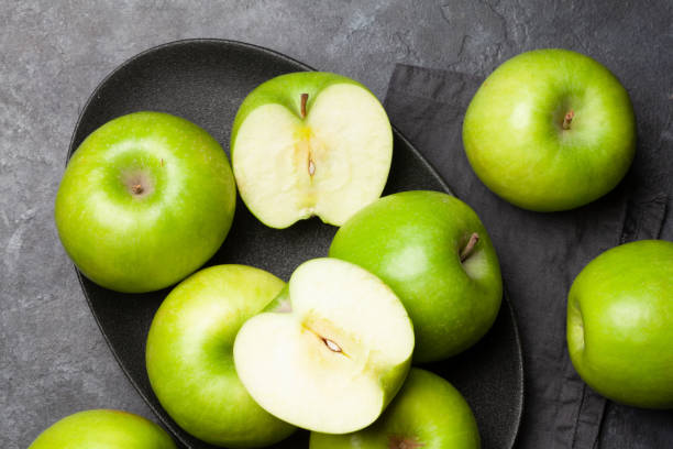 어두운 돌 테이블에 잘 익은 녹색 사과 과일 - granny smith apple 이미지 뉴스 사진 이미지