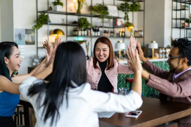 Photo of Asians Millennials congratulating each other for job well done.