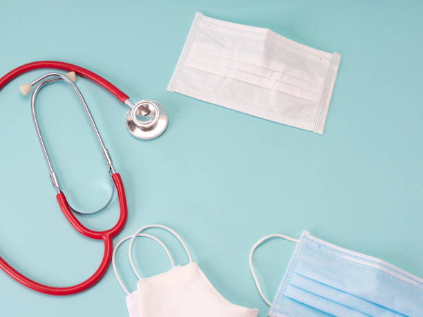 istock Protective mask and stethoscope, medical gear on light blue background. 1217829736