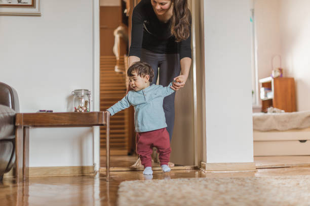 istock Baby boy, learning to walk with his mother 1217829821