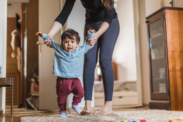 istock Baby boy, learning to walk with his mother 1217829904