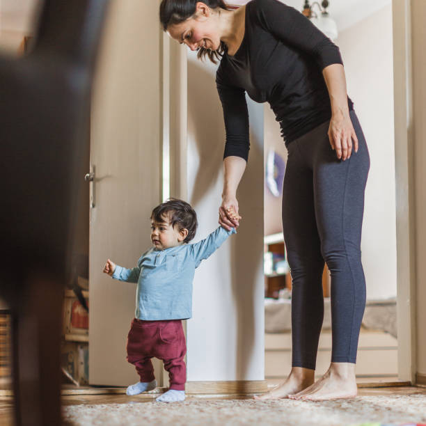istock Baby boy, learning to walk with his mother 1217830496