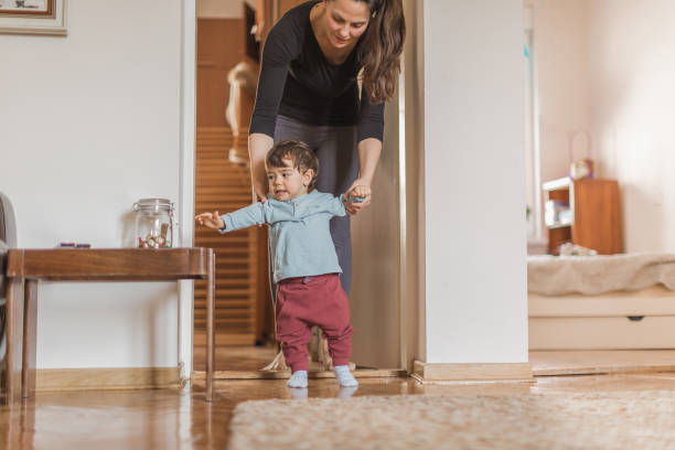 istock Baby boy, learning to walk with his mother 1217830498