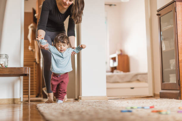 istock Baby boy, learning to walk with his mother 1217830547