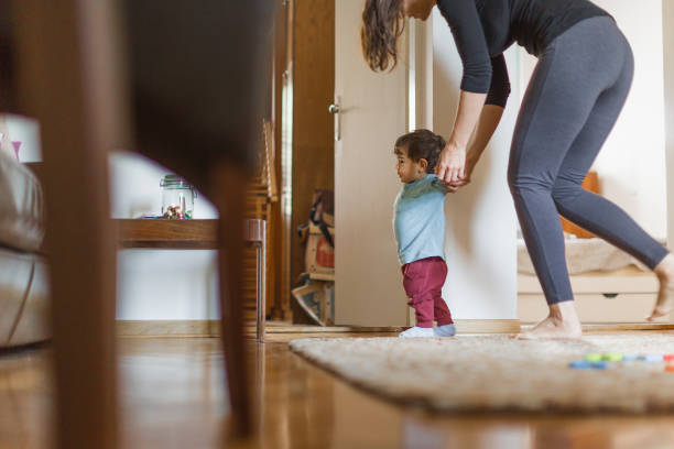 istock Baby boy, learning to walk with his mother 1217830668