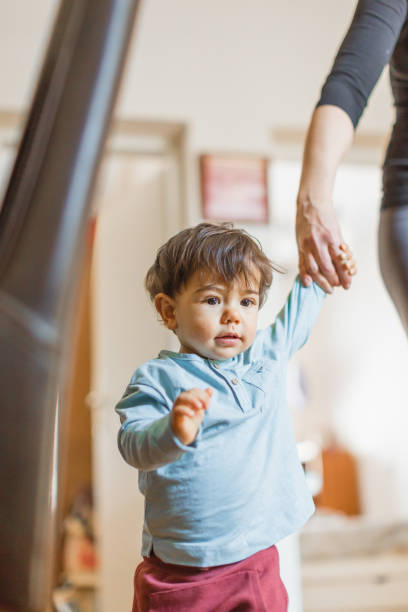 istock Baby boy, learning to walk with his mother 1217830750