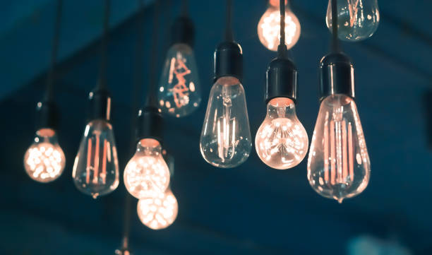 istock Vintage glowing gold filament light bulb 1217830851