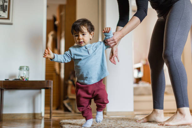 istock Baby boy, learning to walk with his mother 1217831082