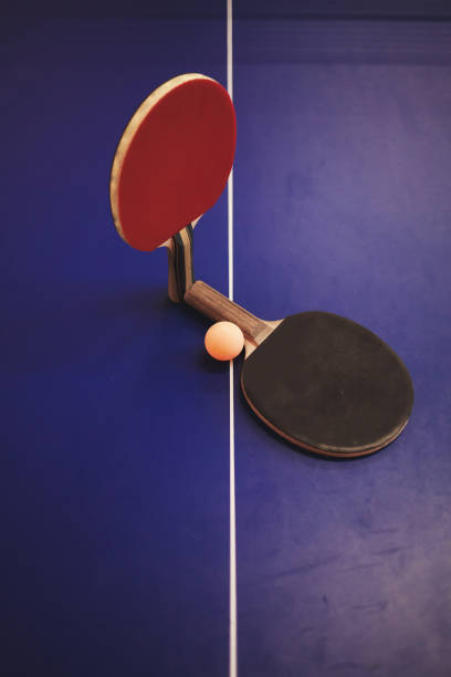 zwei tennisschläger auf dem tisch - table tennis tennis table indoors stock-fotos und bilder