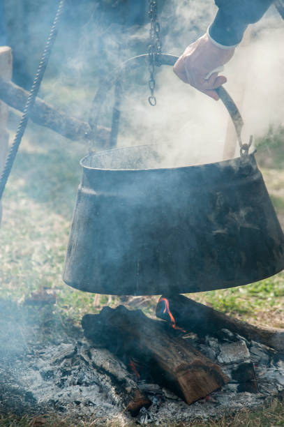 istock Cooking dinner in iron kettle at bonfire. Bonfire cooking. Selective focus, blur 1217835654