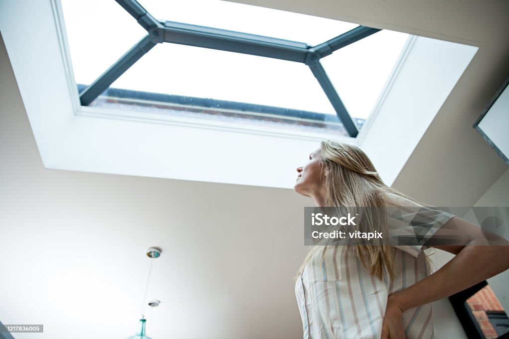Natural Sky Light Woman looking into the skylight Skylight Stock Photo