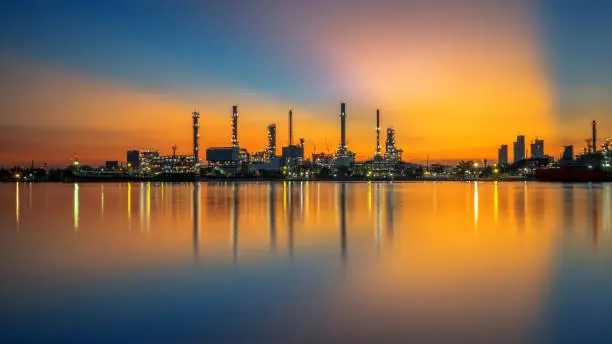 Photo of Oil refinery and sunrise at the Chao Phraya River, Thailand, petrochemical Industrial, oil refinery and oil industry.