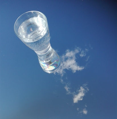 vaso de agua en el espejo contra el cielo photo