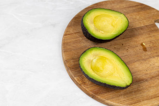 istock Avocado sliced on half on the cutting wooden board 1217839944